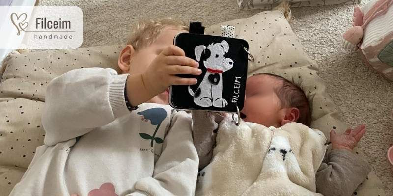 testvérek nézegetik a kontrasztos könyvet